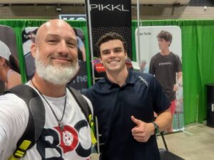 PickleCon 2024: Pickleball Coach Dave with a PIKKL representative at the vendor booth, smiling and celebrating the pickleball community.