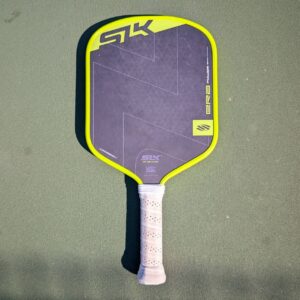 Selkirk SLK Era Power pickleball paddle, widebody shape, yellow and black, on a pickleball court