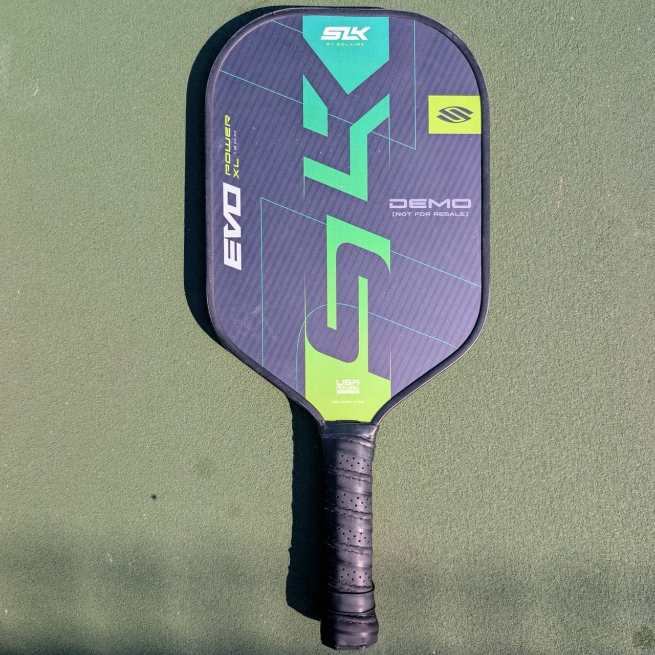 Selkirk SLK Evo Power pickleball paddle, 13mm, green and teal, XL shape, on a pickleball court
