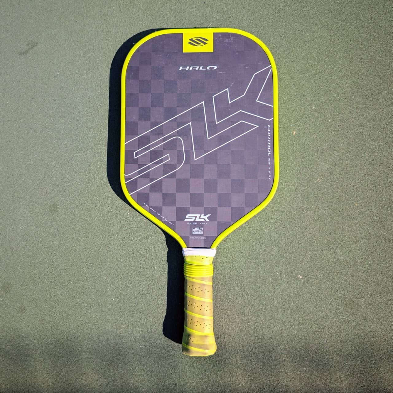 Selkirk SLK Halo Control pickleball paddle, 16mm, yellow trim, on a pickleball court