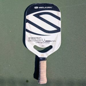 Selkirk Vanguard Power Air Invikta pickleball paddle with aero handle, white and gray, on a pickleball court